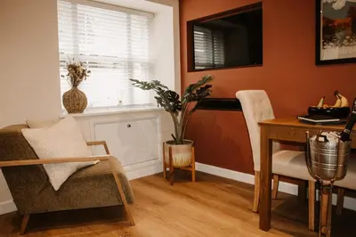a living room with a table and a chair at The Old Brewery in Ulverston