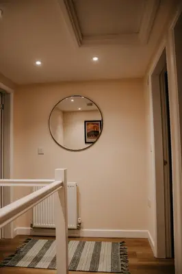a hallway with a round mirror on the wall at The Old Brewery in Ulverston