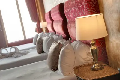 a bed with a lamp on a table next to a window at Boutique 56 in Liverpool