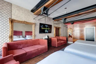 a hotel room with a couch and a bed and a mirror at Boutique 56 in Liverpool