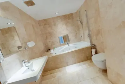 a bathroom with a tub and a toilet and a sink at Boutique 56 in Liverpool