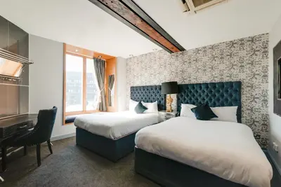 a hotel room with two beds and a desk at Boutique 56 in Liverpool