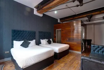 a bedroom with two beds and a blue wall at Boutique 56 in Liverpool