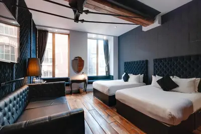 a hotel room with two beds and a couch at Boutique 56 in Liverpool