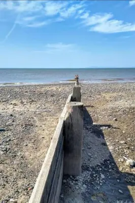 a concrete barrier on a beach with the ocean at Lovely Centralised 1Bed Apt Near Town Centre & Beach - Free Wi-Fi & Parking in Fleetwood