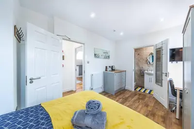 a bedroom with a bed with a yellow blanket at Stunning house close to the stadium + Hot tub! in Liverpool