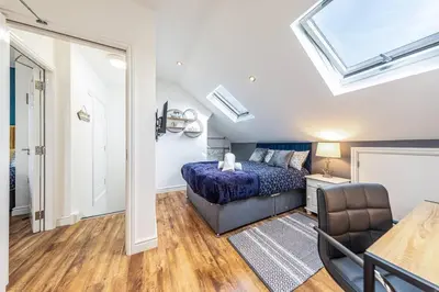 a bedroom with a bed and a couch and a window at Stunning house close to the stadium + Hot tub! in Liverpool