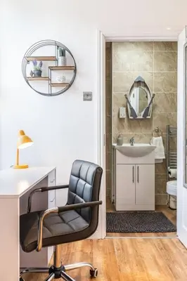 a bathroom with a chair and a desk and a sink at Stunning house close to the stadium + Hot tub! in Liverpool