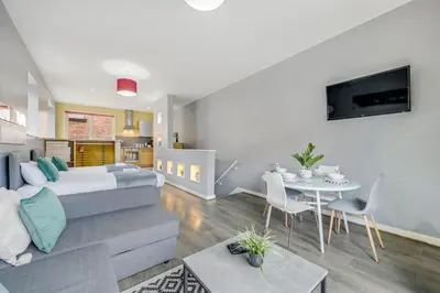 a bedroom and living room with a bed and a table at Host & Stay - Campbell Square Roof Terrace Apartment in Liverpool
