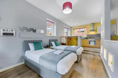 a bedroom with two beds and a kitchen at Host & Stay - Campbell Square Roof Terrace Apartment in Liverpool