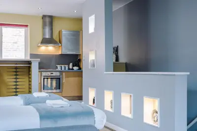 a room with two beds and a kitchen at Host & Stay - Campbell Square Roof Terrace Apartment in Liverpool