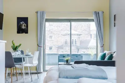 a bedroom with a bed and a table and a large window at Host & Stay - Campbell Square Roof Terrace Apartment in Liverpool