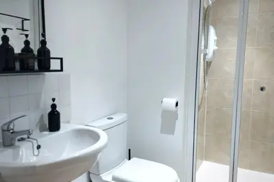 a bathroom with a sink and a toilet and a shower at Stylish Apartment in City Centre with Parking in Preston