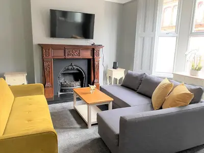 a living room with a couch and a fireplace at Beautiful Victorian Townhouse in Liverpool