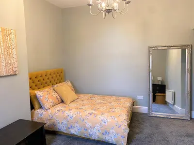 a bedroom with a bed and a mirror at Beautiful Victorian Townhouse in Liverpool