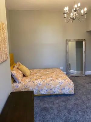 a bedroom with a bed and a mirror at Beautiful Victorian Townhouse in Liverpool