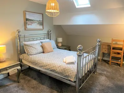 a bedroom with a bed and a desk and a chair at Beautiful Victorian Townhouse in Liverpool
