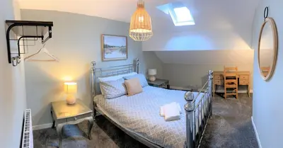 a bedroom with a bed and a desk and a lamp at Beautiful Victorian Townhouse in Liverpool