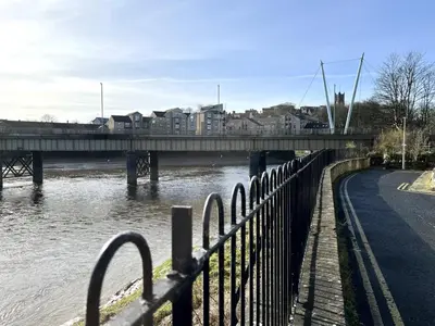 a bridge over a river next to a road at River Terrace in Lancaster