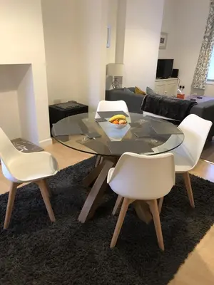 a dining room with a glass table and white chairs at River Terrace in Lancaster