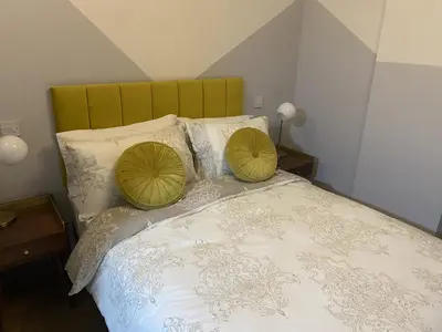 a bed with two green pillows on top of it at Urban Pod Hotel Liverpool in Liverpool