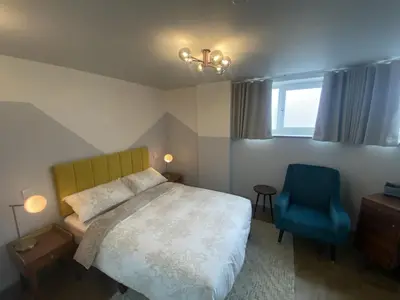 a bedroom with a bed and a blue chair at Urban Pod Hotel Liverpool in Liverpool