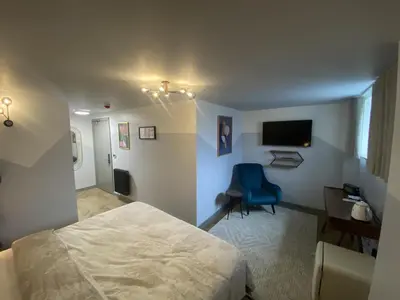 a bedroom with a bed and a blue chair at Urban Pod Hotel Liverpool in Liverpool