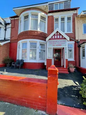 a red brick house with a fire hydrant in front of it at Nevele in Blackpool