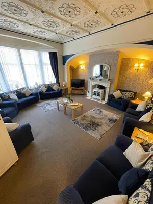 a living room with blue furniture and a coffered ceiling at Nevele in Blackpool