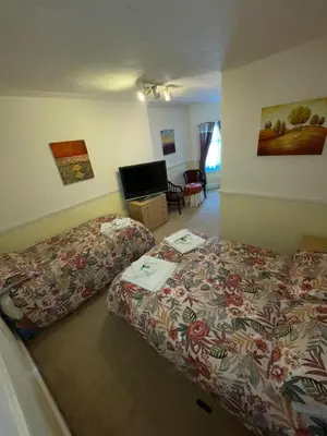 a hotel room with two beds and a desk at Nevele in Blackpool