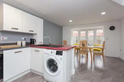 a kitchen with a washing machine and a table at Main Street Town House in Leyland