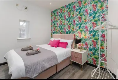 a bedroom with a large bed with a floral wallpaper at Luxury Mirror Party Pad with 4 Bedrooms! in Liverpool