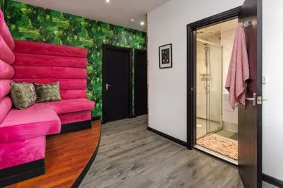 a room with a pink couch and a glass door at Luxury Mirror Party Pad with 4 Bedrooms! in Liverpool