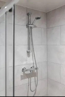 a shower with a shower head in a bathroom at Luxury Mirror Party Pad with 4 Bedrooms! in Liverpool