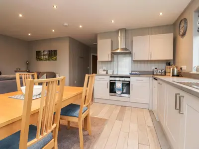 a kitchen and dining room with a wooden table and chairs at Beech Lodge in Preston