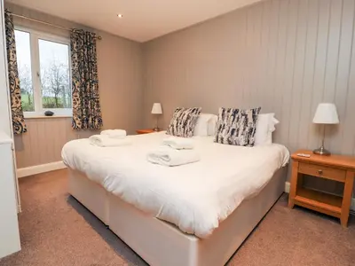 a bedroom with a large white bed with towels on it at Beech Lodge in Preston