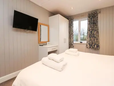 a bedroom with two white beds and a flat screen tv at Beech Lodge in Preston