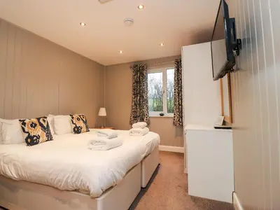 a small bedroom with a bed and a window at Beech Lodge in Preston