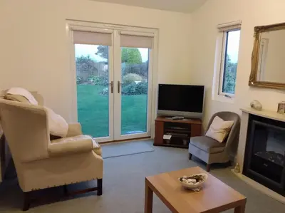 a living room with a fireplace and a television at Coastal Garden Lodge in Preesall