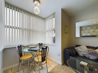a living room with a table and chairs and a couch at Pearl Suite in Blackpool