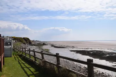 a view of a beach with a fence and the ocean at 32 Bayview Oceans Edge in Morecambe