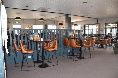a restaurant with orange chairs and tables in a room at 32 Bayview Oceans Edge in Morecambe