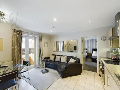 a living room with a couch and a kitchen at Sandbanks Suite in Blackpool