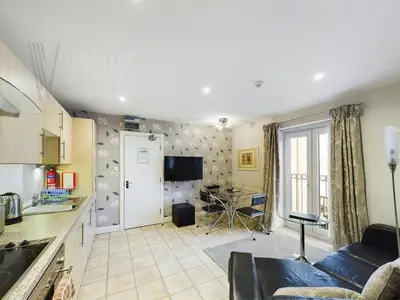 a kitchen and living room with a couch and a table at Sandbanks Suite in Blackpool
