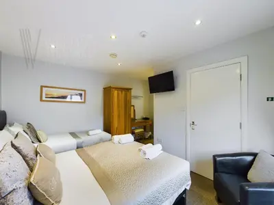 a living room with two beds and a couch at Sandbanks Suite in Blackpool
