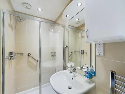 a bathroom with a sink and a shower at Sandbanks Suite in Blackpool