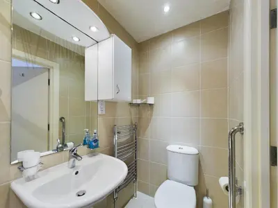 a bathroom with a sink and a toilet and a mirror at Sandbanks Suite in Blackpool