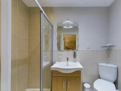 a bathroom with a toilet and a sink and a shower at Sunrise Suite in Blackpool