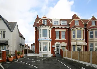 a house with a parking lot in front of it at Sunrise Suite in Blackpool