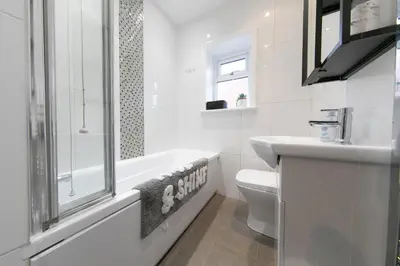 a white bathroom with a toilet and a sink at Stunning house near Blackpool attractions in Blackpool